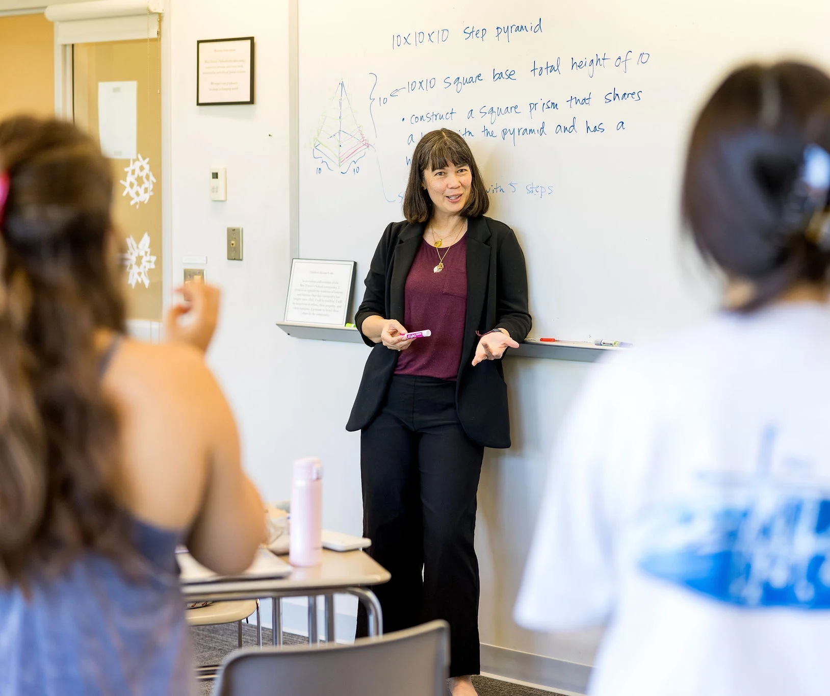 math teacher discussing calculus concepts with students while standing at a whiteboard