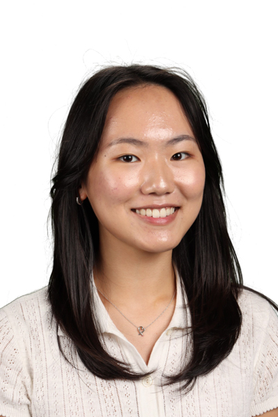 A young woman with long dark hair smiles at the camera in a professional headshot.