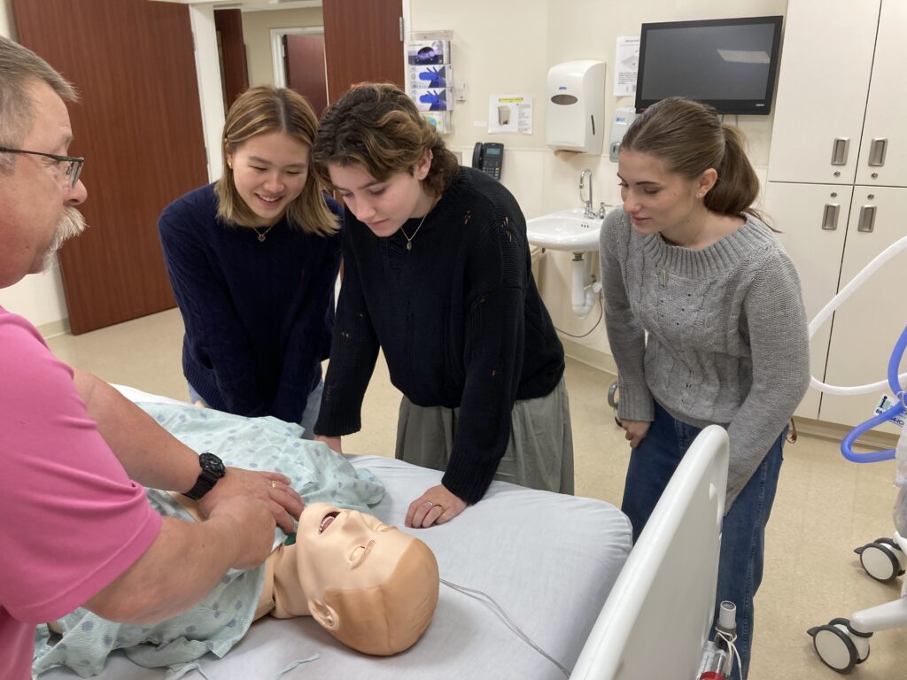 students learning about CPR with a test dummy